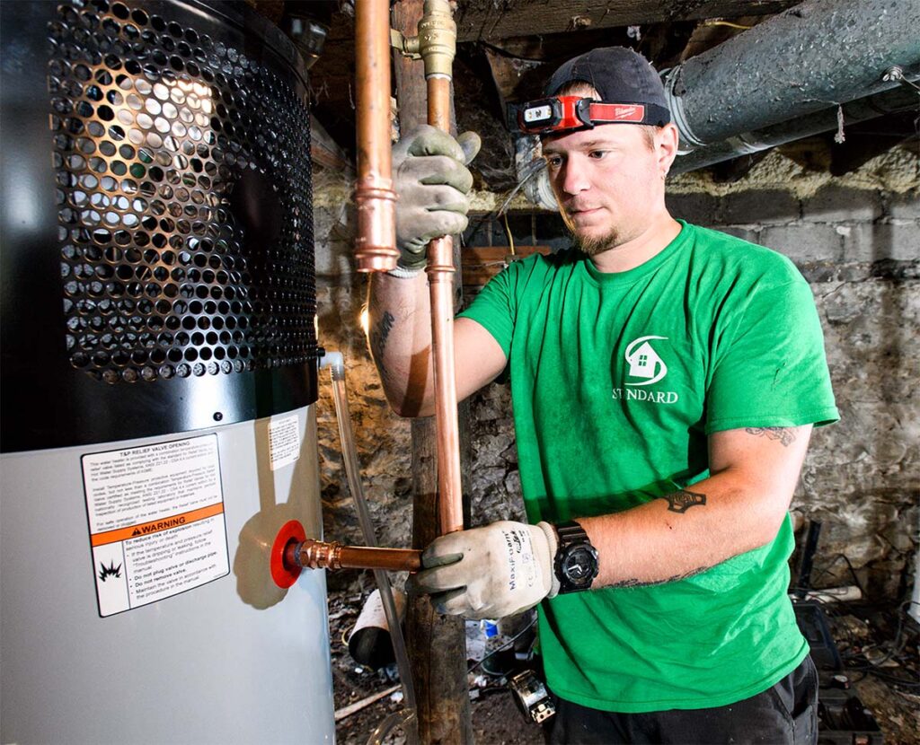 Standard technician installing copper pipe for water heater