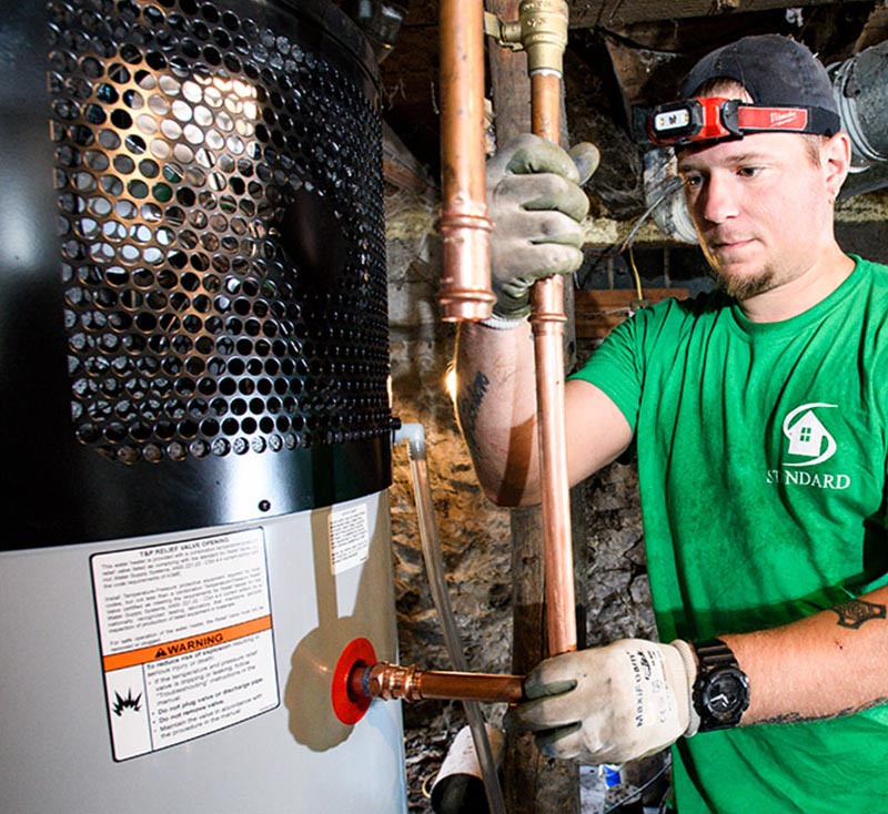 Standard technician installing copper pipe for water heater