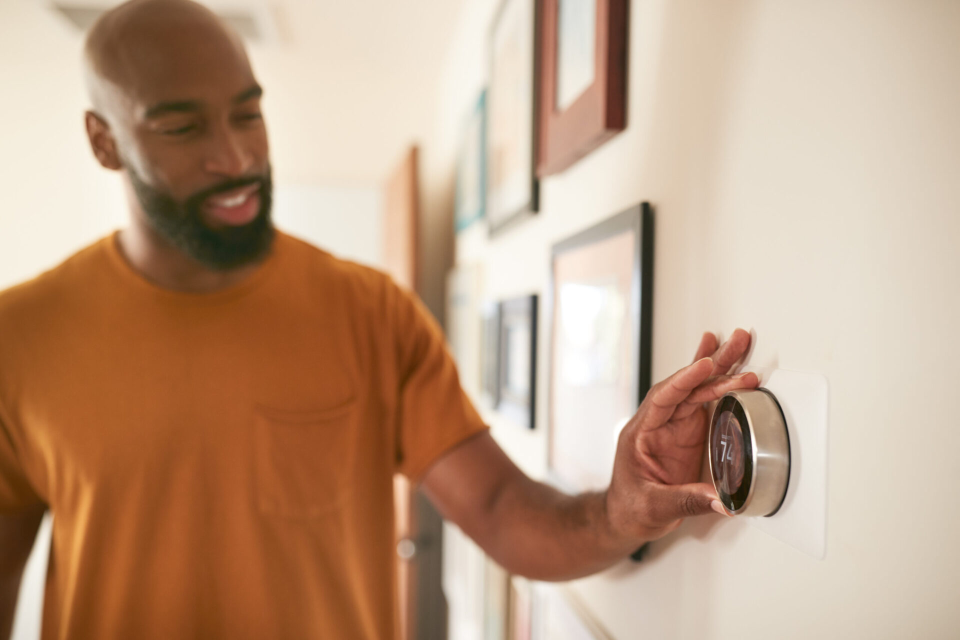 adult adjusting the thermostat of the new smart HVAC system in their home