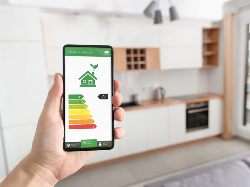 energy efficiency mobile app on a smartphone screen with a kitchen in the background