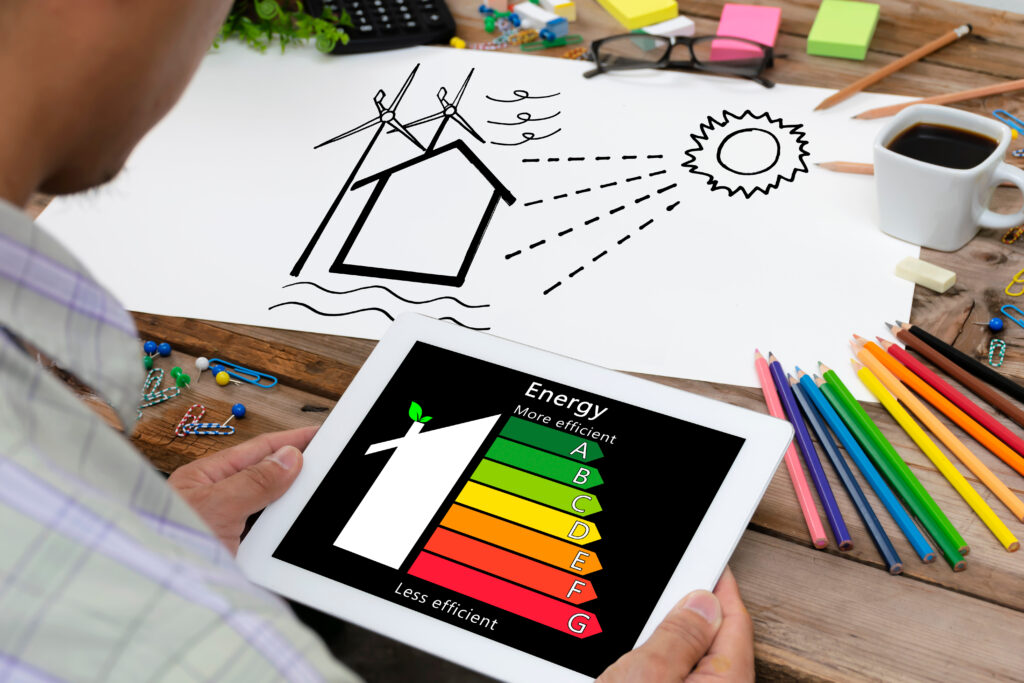 A smartphone with an energy efficiency diagram lays on a table on top of designs and other papers  